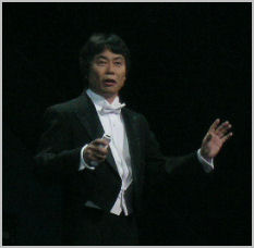 Miyamoto at E3 2006, conducting with the motion tracking Wii Controller